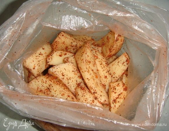 Картофель чистим и режем крупными дольками. Складываем в фасовочный пакет. Добавляем соль, перец черный и красный, приправу для картофеля. Несколько раз встряхиваем пакет.
