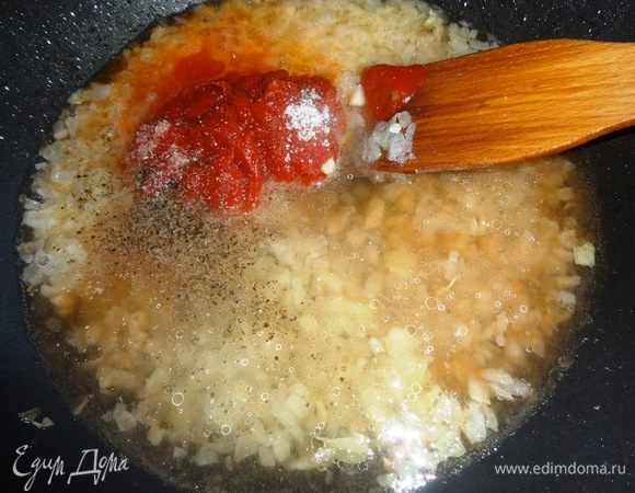 К обжаренному луку влить воду, положить томатную пасту, соль, сахар, перец, размешать и потушить 5 мин.