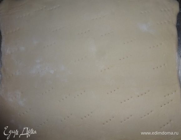 Пластины теста наколоть вилкой. С помощью скалки выложить на противень. Поставить в духовку, разогретую до 200°C и выпекать 20–25 мин.