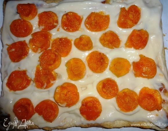 Крем мысленно (или реально) разделить на 3 части. На вготовый корж выложить 2/3 одной части крема. Половинки абрикосов как бы слегка вывернуть и разложить на креме срезом вверх.