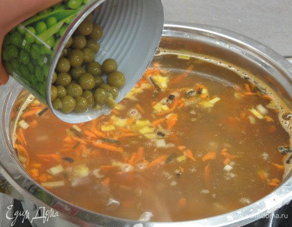 После этого добавляем горошек (без жидкости) и натертые на мелкой терке яйца. Варим еще 5 минут, затем пробуем на соль-перец и, если есть необходимость, солим и приправляем суп перцем.
