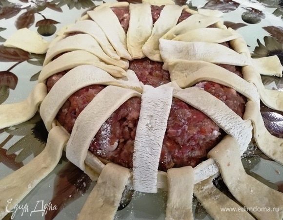 Возьмем вторую длинную полосочку теста. Снова обматываем фарш. Затем загнутые сверху края опускаем вниз, а те, что внизу, подниманием вверх. Снова обматываем полоской теста и, чередуя, поднимаем-опускаем края теста.
