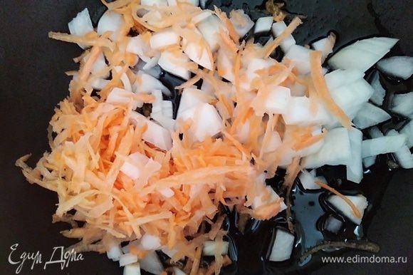 Разогреть растительное масло в сковородке. Обжарить нарезанный кубиками лук и тертую морковь около 2 минут, помешивая.