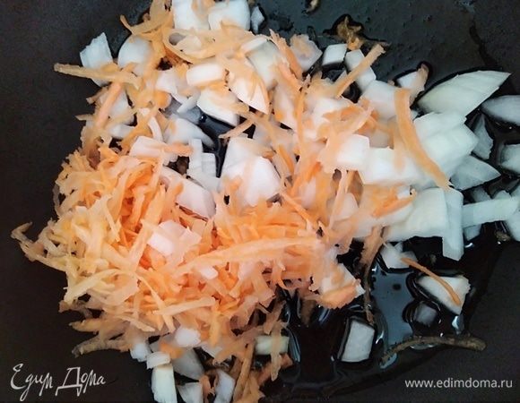 Разогреть растительное масло в сковородке. Обжарить нарезанный кубиками лук и тертую морковь около 2 минут, помешивая.