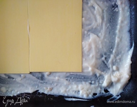 Форму немного смазать маслом. По дну распределить 2 ложки соуса бешамель. Выложить первый слой листов для лазаньи. У меня те, которые отваривать не нужно. Соус я в этот раз не процеживала, комочки маленькие были, но они в готовом блюде не чувствуются.