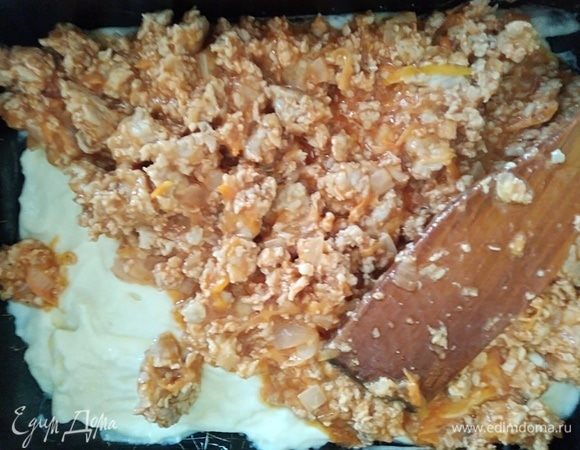 Мясную начинку поделить на 2 части. Одну часть выложить сверху на соус.