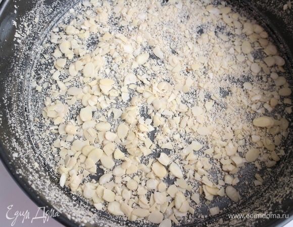 Дно разъемной формы смазать сливочным маслом, посыпать смесью панировочных сухарей и миндальных лепестков (2 ст. л.) — дно и борта.