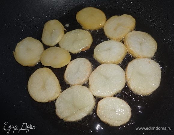 В сковороде разогреть растительное масло и обжарить на нем кружки картофеля с двух сторон до румяной корочки.