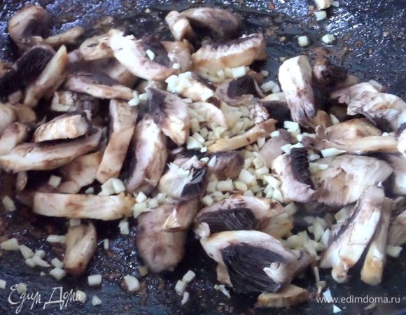 А в вок поместить грибы и чеснок, добавить оливковое масло.