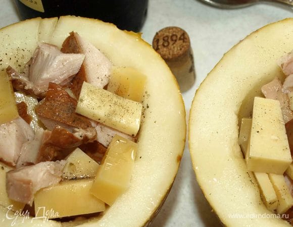 Складываем курицу и сыр в чашу из дыни. Расклад любой, как вам нравится. Поливаем вином, добавляем перец и соль (при желании).