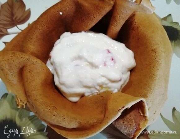 В небольшую пиалу укладываем блин, внутрь кладем 2 столовые ложки начинки. Собираем края блинчика, формируя кулечек.