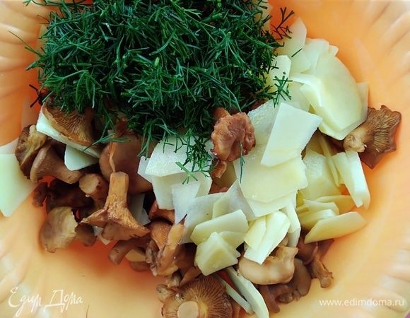 Картофель почистить и нарезать тонкими слайсами, смешать с лисичками и рубленым укропом. Посолить.
