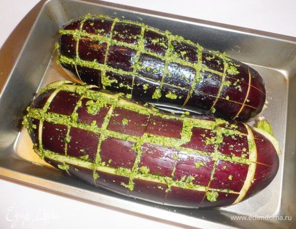 Баклажаны переложить в форму для выпечки подходящего размера. Они не должны потерять форму при запекании. Заполнить соусом песто продольные надрезы.