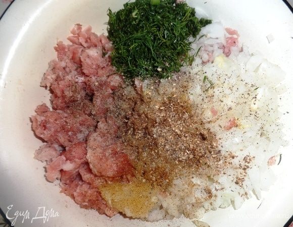 В фарш добавить лук, чеснок, перец, кориандр, соль, зелень. Массу перемешать.