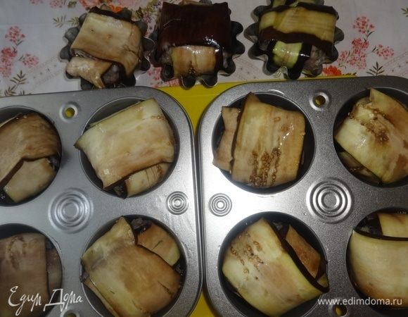 Таким образом сделать все остальные фрикадельки. Формочки смазать растительным маслом и положить в них фрикадельки в баклажанах стыками вниз. В каждую формочку налить по 2 ст. ложки воды.