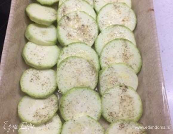 Форму для запекания смазываем маслом и выкладываем кабачок, нарезанный кружочками. Солим, перчим, сбрызгиваем оливковым маслом. Запекаем в духовке 10–15 минут при температуре 220–250°C. Все зависит от того, какую степень запекания любите вы.
