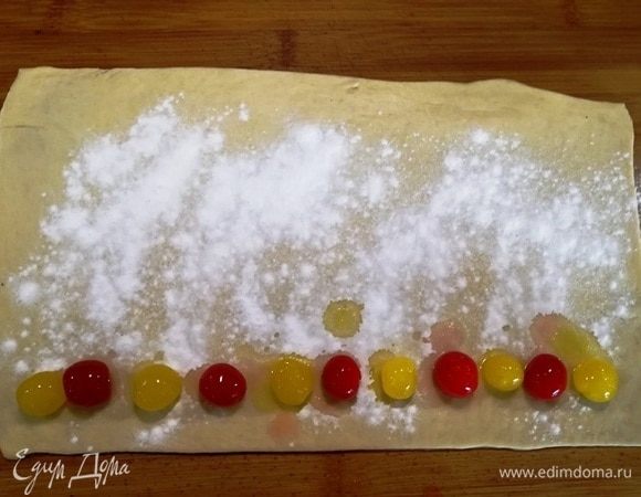 Посыпаем тесто крахмалом, выкладываем вишню.