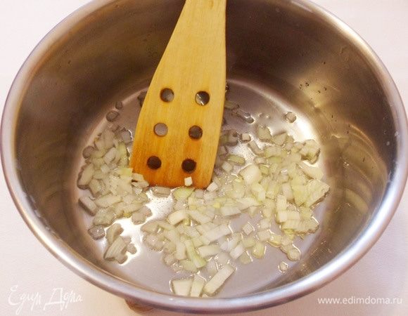 В глубокой широкой кастрюле с толстым дном разогреть растительное масло и обжарить мелконарезанный репчатый лук до прозрачности.