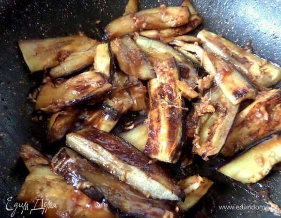 Перенести все баклажаны обратно в сковороду и вылить заливку, прогреть пару минут, помешивая.