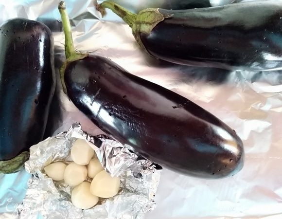 Духовку разогреть до 170°C. Баклажаны наколоть вилкой, чеснок очистить, смазать маслом и запечь все в духовке. Чеснок завернуть в фольгу.