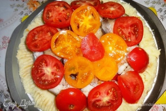 Выложить кружки помидоров на рыбу смазанной стороной вниз. Сбрызнуть помидоры оставшимся маслом. Поставить форму в духовку, нагретую до 180°C, и запекать блюдо в течение 35–40 мин.