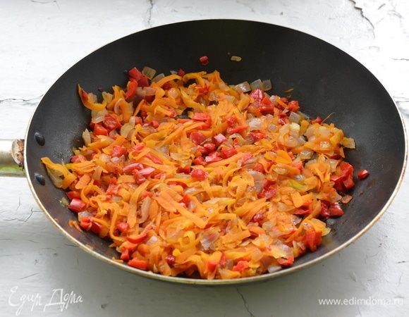 В это время можно параллельно заняться начинкой. Лук, морковь, перец почистить, промыть. Лук и перец нарезать мелкими кубиками, морковь натереть на терке. На растительном масле в течение 3–4 минут пожарить лук, добавить морковь и перец и тушить еще 7–8 минут. Дать зажарке остыть. Для крема взбить сметану с творожным сыром, добавить мелко нарезанную зелень.