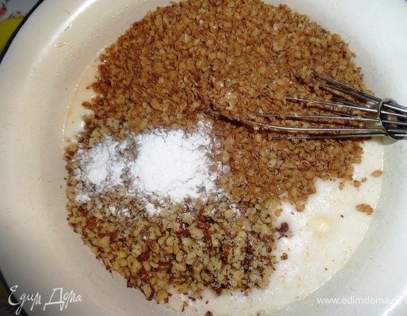 В молочно-яичную смесь всыпать орехи, гречневые хлопья и разрыхлитель. Массу перемешать.