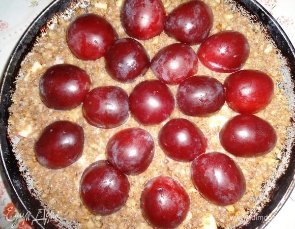 Выложить половинки слив на тесто разрезом вниз в произвольном порядке.