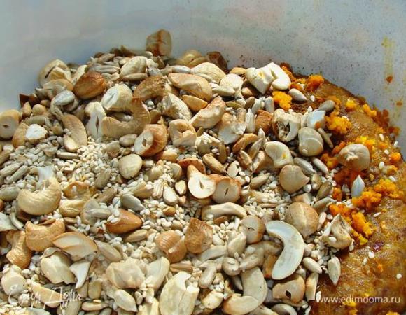 Горячие орешки сразу высыпать к финиковой массе. Добавить цедру одного апельсина, корицу, кардамон и все тщательно перемешать руками, смоченными в воде.