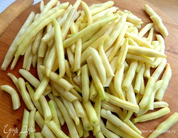 Фасоль промыть, отрезать кончики и нарезать пополам.