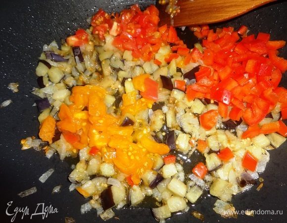 В сковороду с овощами добавить нарезанные помидоры и перец, перемешать. Продолжать обжаривать все овощи еще 3–5 мин.