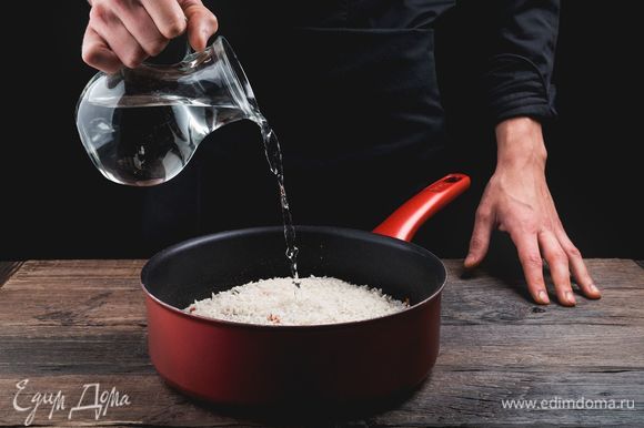 Залейте рис горячей водой, чтобы она покрывала его примерно на 2 см.