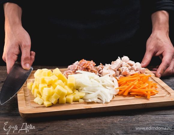 Нарежьте лук и морковь соломкой, картофель — кубиками, бекон — полосками, курицу — ломтиками.<br />
 