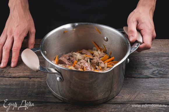 Разогрейте масло в кастрюле с толстым дном. Обжарьте лук с морковью, мясо.