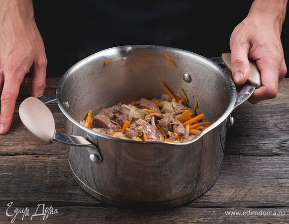 Разогрейте масло в кастрюле с толстым дном. Обжарьте лук с морковью, мясо.