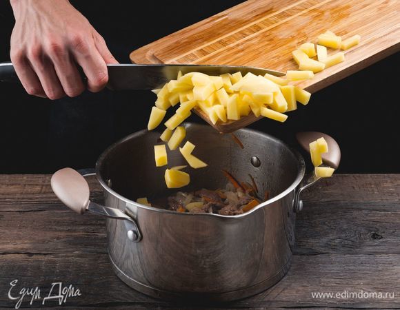 Добавьте картофель, залейте горячей водой и поставьте вариться на среднем огне.