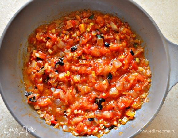 На помидорах (3–4 шт.) сделайте сверху крестообразные надрезы, поместите на на 1–2 мин в кипяток, а затем — в холодную воду. Снимите кожицу, мякоть мелко порубите и добавьте в сковороду к луку. Добавьте мелконарезанный базилик (1 веточка), соль, сахар и тушите в течение 10 мин., периодически помешивая. Приправьте молотым перцем.