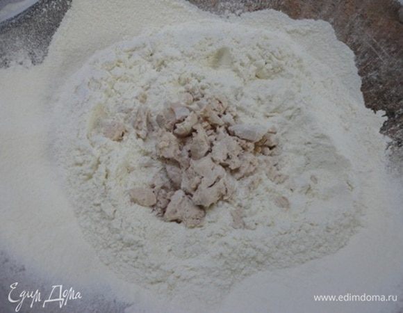 Примерно в половину муки крошим дрожжи, растираем руками.
