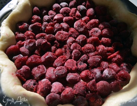 Выложить замороженную вишню. Очень плотно распределить ее по основанию пирога.