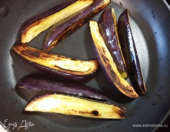 Баклажаны (если крупные, достаточно и 3 шт.) разрезать на крупные дольки, посолить и отставить в сторону. Когда баклажаны выделят сок, промокнуть их бумажной салфеткой и кисточкой смазать оливковым маслом. Обжарить на сковороде до золотистого цвета.