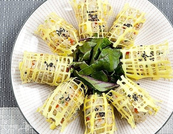 Посыпьте яичные сетки черным кунжутом по щепотке на каждую. Подавайте блюдо со свежей зеленью.