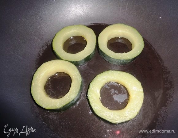 Кольца цукини обсушить бумажным полотенцем. В сковороду налить масло для колец. Выложить кольца и обжарить сначала с одной стороны до румяности.
