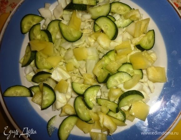 Выложить нарезанные перец и огурец поверх капусты.