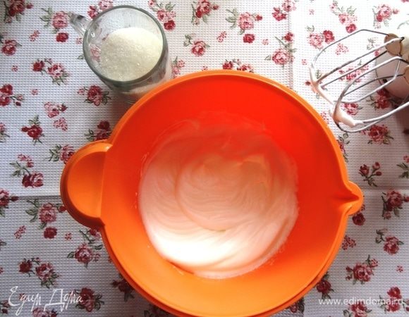 Отделить белки от желтков, добавить щепотку соли, лимонный сок и взбить до устойчивых пиков, постепенно ввести 100 г сахара.