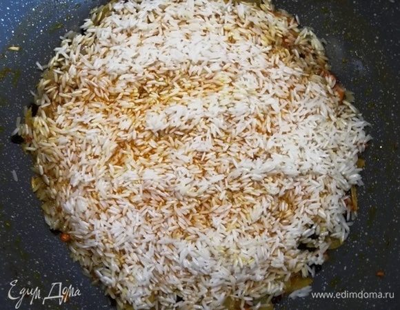Выкладываем ровным слоем рис без жидкости.