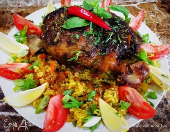 Украшаем разобранный плов зеленью, помидорами и дольками лимона.