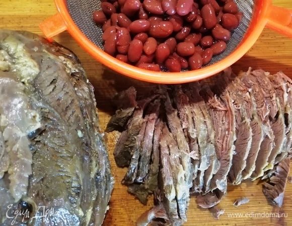 Сольем жидкость из консервированной фасоли, говядину нарежем тонкими пластинками. Мелко нарезать говядину не советую, она — главный ингредиент в салате.
