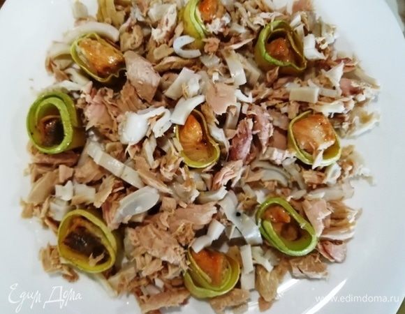 Собираем салат. На большую плоскую тарелку ставим рулетики из кабачка и форели. Выкладываем тунец с кальмарами.