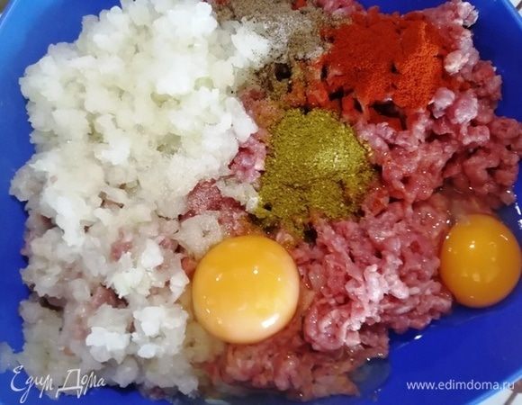 Прокручиваем индейку на мясорубке вместе с луком. Добавляем специи и яйца. Перемешиваем.