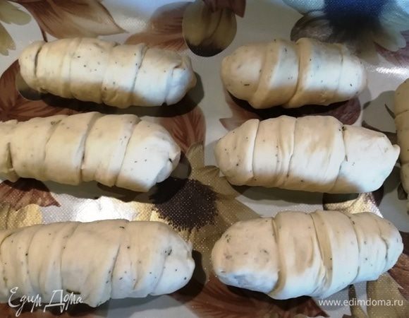 Каждую сосисочку с сыром оборачиваем полоской теста.